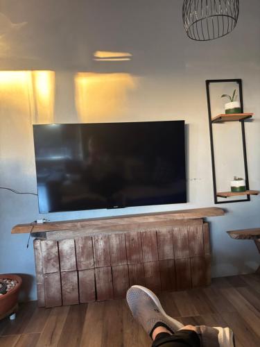 a person laying on the floor in front of a large television at Casa vista do Vale in Farroupilha