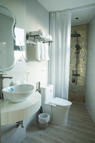 a white bathroom with a sink and a toilet at Alphan Hotel in Vạn Ninh