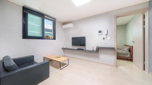 a living room with a couch and a television at Sokcho Jaja Ocean View Pension in Sokcho