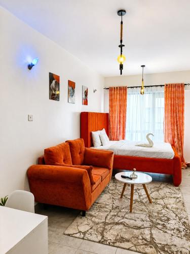 a bedroom with a bed and a couch and a table at Imanis comfort in Ongata Rongai 