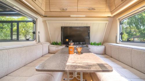 a living room with a table and a tv in a trailer at gyeongju yongcheonsu caravan in Gyeongju
