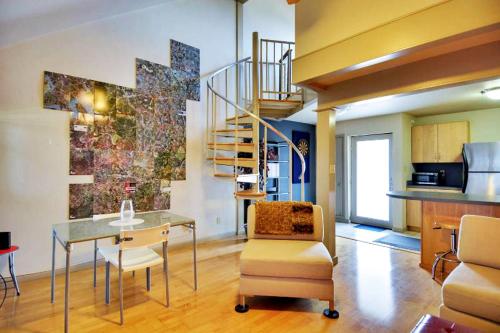 a living room with a glass table and a staircase at Barton Hills Condominiums in Austin