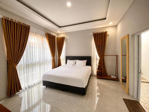a bedroom with a bed and a large window at Pondok DlodPoh in Karangasem