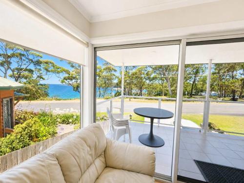 a living room with a couch and a table at Harbour Haven - steps from Ulladulla Harbour in Ulladulla
