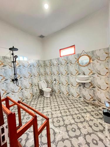 a bathroom with a toilet and a sink at Mahoney Homestay in Kuta Lombok
