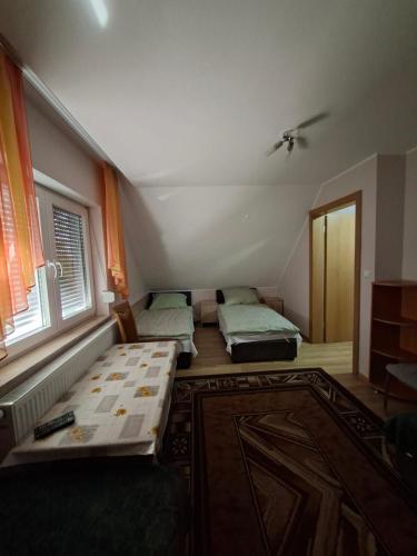 a room with three beds and a window at Noclegi Dobrzeń Wielki in Dobrzeń Wielki