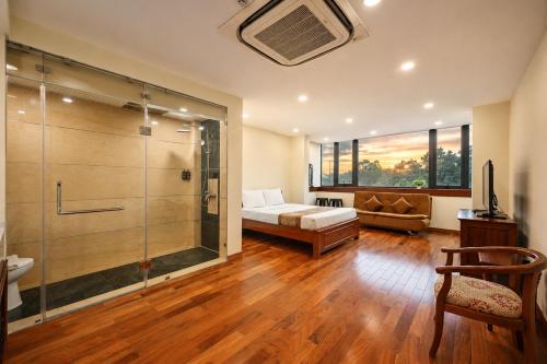 a bathroom with a bed and a shower in a room at Red Sun Airport Saigon Hotel in Ho Chi Minh City