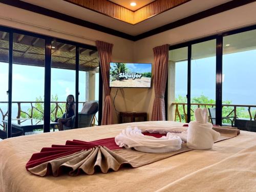 a hotel room with a bed with towels on it at Infinity Heights Resort in Siquijor