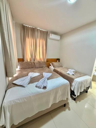 a bedroom with two beds and a window at Flat Carneiros - Hotel Marinas in Tamandaré