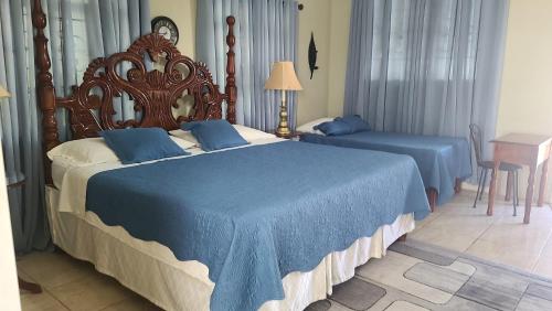 zwei Betten in einem Hotelzimmer mit blauer Bettwäsche in der Unterkunft Lorenton Hideaway in Lucea