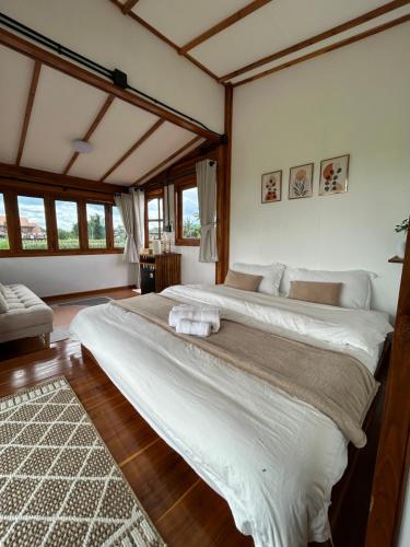 a bedroom with two large beds in a room at Nonnatatonview นอนนาตาทนวิว in Phayao