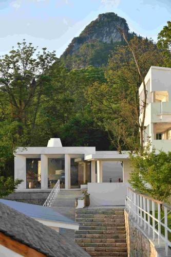 a house with a mountain in the background at Zhiye Resort Hotel in Guanling