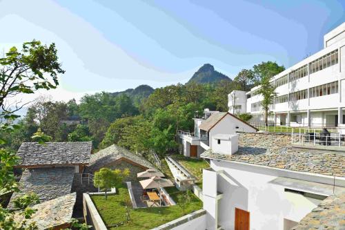 an aerial view of roofs of buildings with mountains in the background at Zhiye Resort Hotel in Guanling