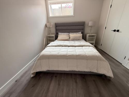 a bedroom with a large bed with a wooden floor at Cozy Suite Near Airport in YYC