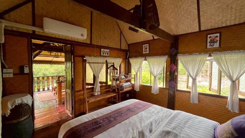 a bedroom with a bed in a room with windows at Elephant House and Pool Villas in Ban Sop Ao