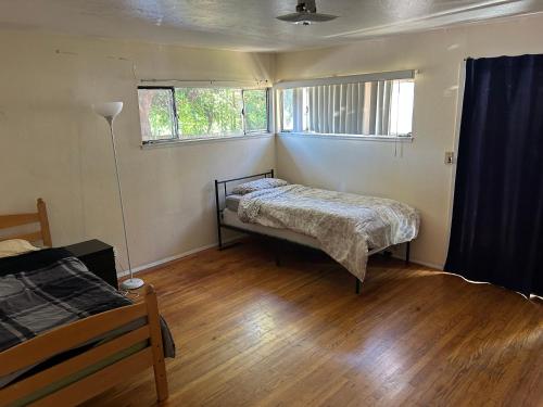 a bedroom with two beds and two windows at 4 Room Sleeps 8plus Tranquil Home in Santa Cruz