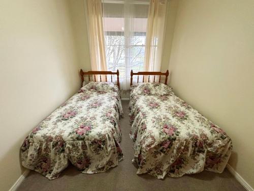 two beds sitting next to each other in a bedroom at Chalkers Unit - Bring your own linen in South West Rocks