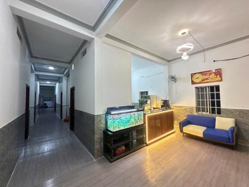 a living room with a blue couch and a fish tank at Nhà Nghỉ 36 in Ga Trảng Bôm
