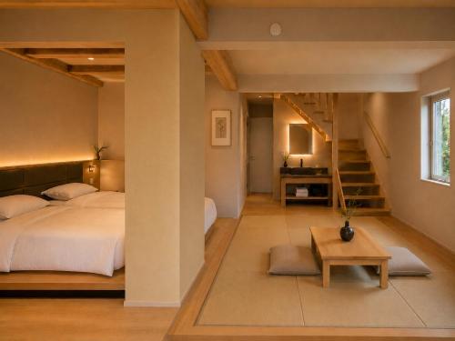 a bedroom with a large bed and a staircase at Hakuba Sun Valley Hotel in Hakuba