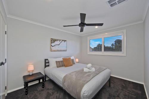 a bedroom with a bed and a ceiling fan at Serenity Place in Mannering Park