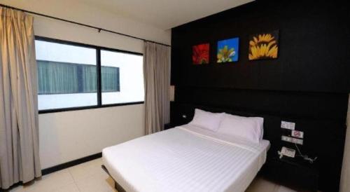 a bedroom with a white bed and a window at U Style Hotel in Ban Phang Khwang Tai