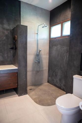 a bathroom with a shower with a toilet and a sink at Seaflower Bungalows in Srithanu