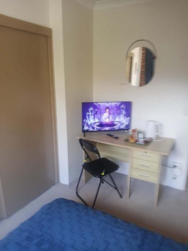 a bedroom with a desk with a chair and a monitor at Connies Retreat in Gold Coast