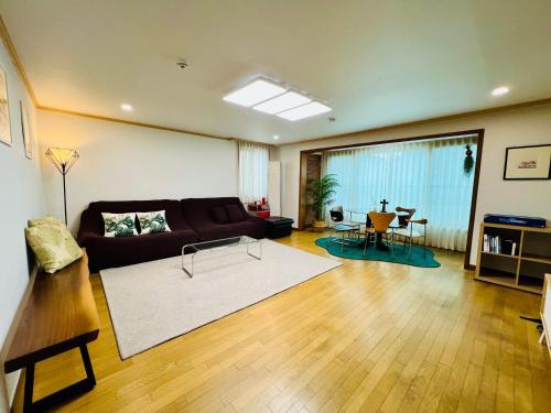 a living room with a couch and a table at Pinkliey House in Ilsan-yŏk
