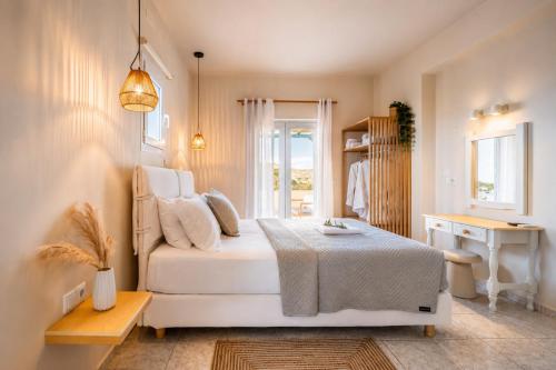 a white bedroom with a bed and a window at Vasiliki Petri Olive House in Petra