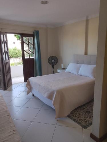 a bedroom with a bed and a door to a patio at Residencial Ribeiro in Salvador