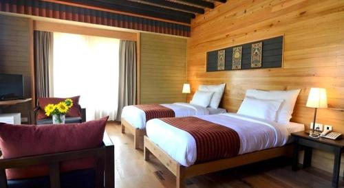a hotel room with two beds and a television at Hotel Valley Thimphu in Tshalunang