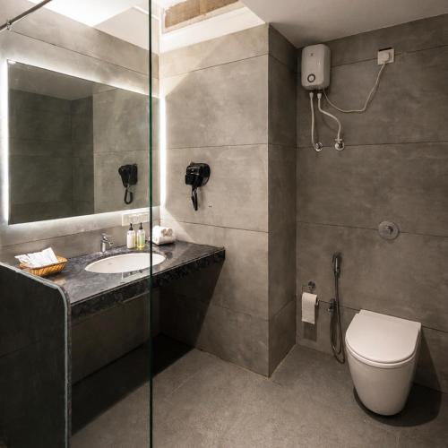 a bathroom with a toilet and a sink and a shower at Rosastays Kutch in Tuna