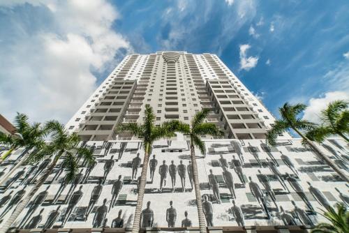 un edificio alto y blanco con palmeras delante en Fortune House Hotel Suites, en Miami