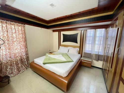 a small bedroom with a bed and a window at Nilgiris Stayz - Home Stay at Ooty in Ooty
