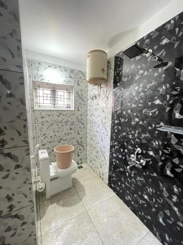 a bathroom with a toilet and a wall covered in butterflies at Nilgiris Stayz - Home Stay at Ooty in Ooty