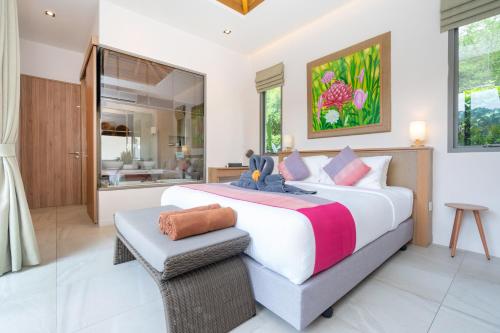 a bedroom with a large bed and a bathroom at Tropical Private Pool Villa Dalaa 9 in Kamala Beach