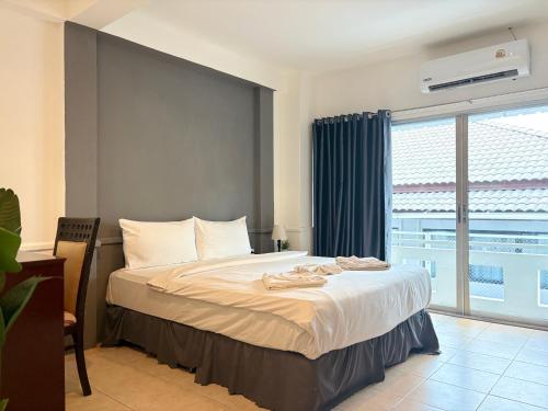 ein Schlafzimmer mit einem Bett und einem großen Fenster in der Unterkunft The LN Hotel in Ko Samui