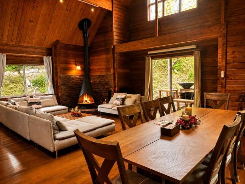 ein Wohnzimmer mit einem großen Holztisch und Stühlen in der Unterkunft RENEST in Kōbe