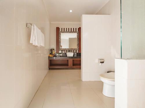 a white bathroom with a sink and a toilet at Terrace Bali Villa in Nusa Dua