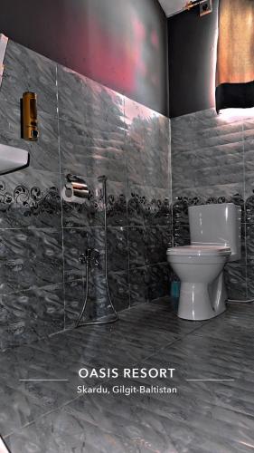 a bathroom with a toilet and a sink at Oasis Resort in Skardu