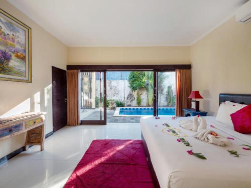 a bedroom with a large bed and a pool at Terrace Bali Villa in Nusa Dua