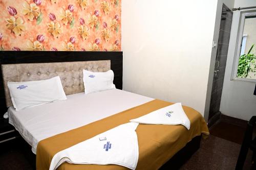 a bedroom with a large bed with a floral wall at Hotel Amaravathi Grand in Vijayawāda