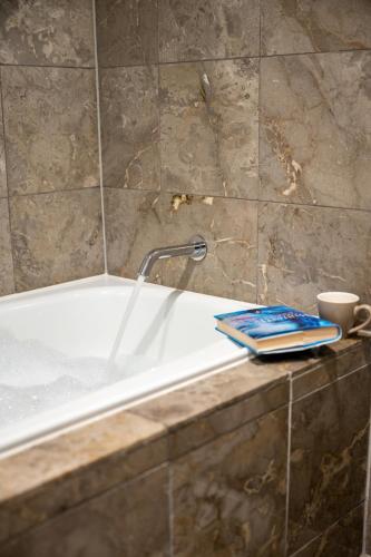 a book sitting on a bath tub in a bathroom at Coogee Bay Boutique Hotel in Sydney