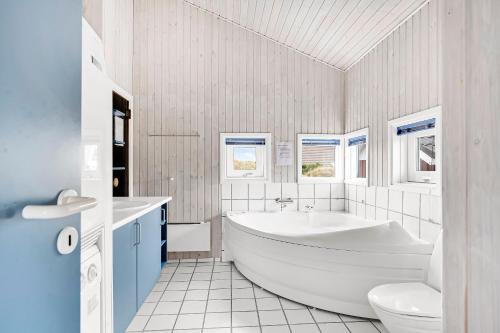 a white bathroom with a tub and a toilet at Holiday House On Fanø Near The Sea in Fanø