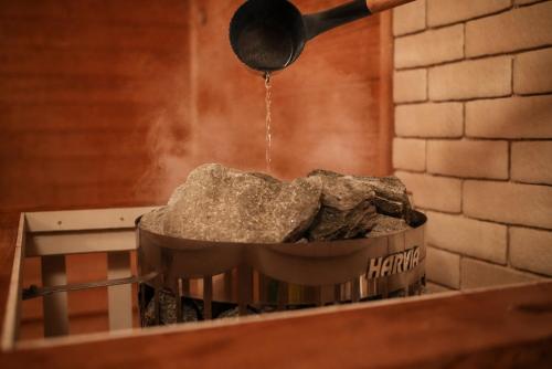 a pot full of rocks and a spatula pouring water into it at Regions Hostel in Yokote