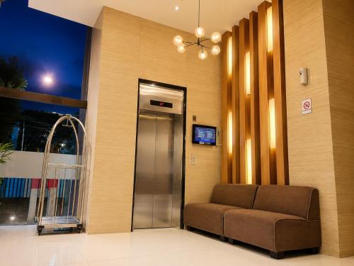 a waiting room with a couch and a elevator at Vio Hotel Pasteur in Bandung