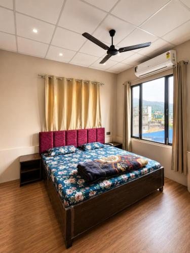 a bedroom with a bed with a large window at Kamlkash niwas homestay in Rishīkesh