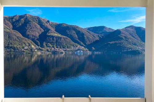 a picture of a lake with mountains at On the Lake 2BR with Garage in Porto Ronco - Happy Rentals in Ronco sopra Ascona