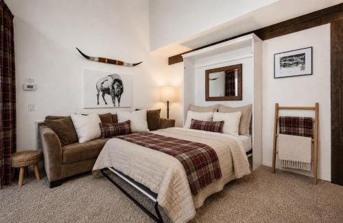 a bedroom with a bed and a couch at Epic Condo walk to Canyon Lodge in Mammoth Lakes
