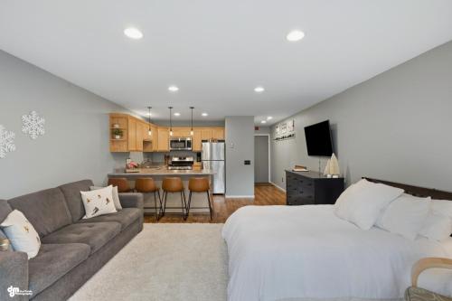 a bedroom with a bed and a couch and a kitchen at Alyeska Mountain Side Retreat! in Girdwood
